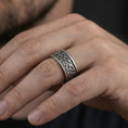 Load image into Gallery viewer, Oxidized Celtic knot band ring worn on finger as a rugged Viking-inspired statement ring with antique depth and artisan texture
