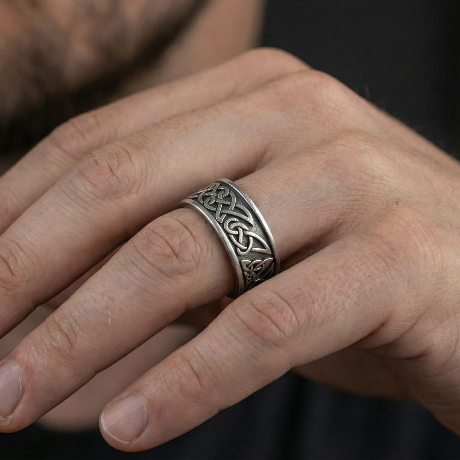 Oxidized Celtic knot band ring worn on finger as a rugged Viking-inspired statement ring with antique depth and artisan texture