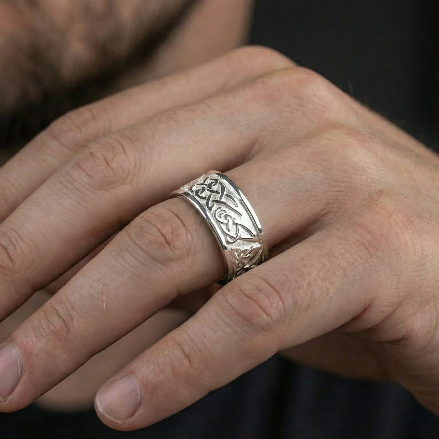 Polished silver Celtic wedding band worn on hand emphasizing timeless knotwork symbolism, daily wear comfort, and minimalist heritage style