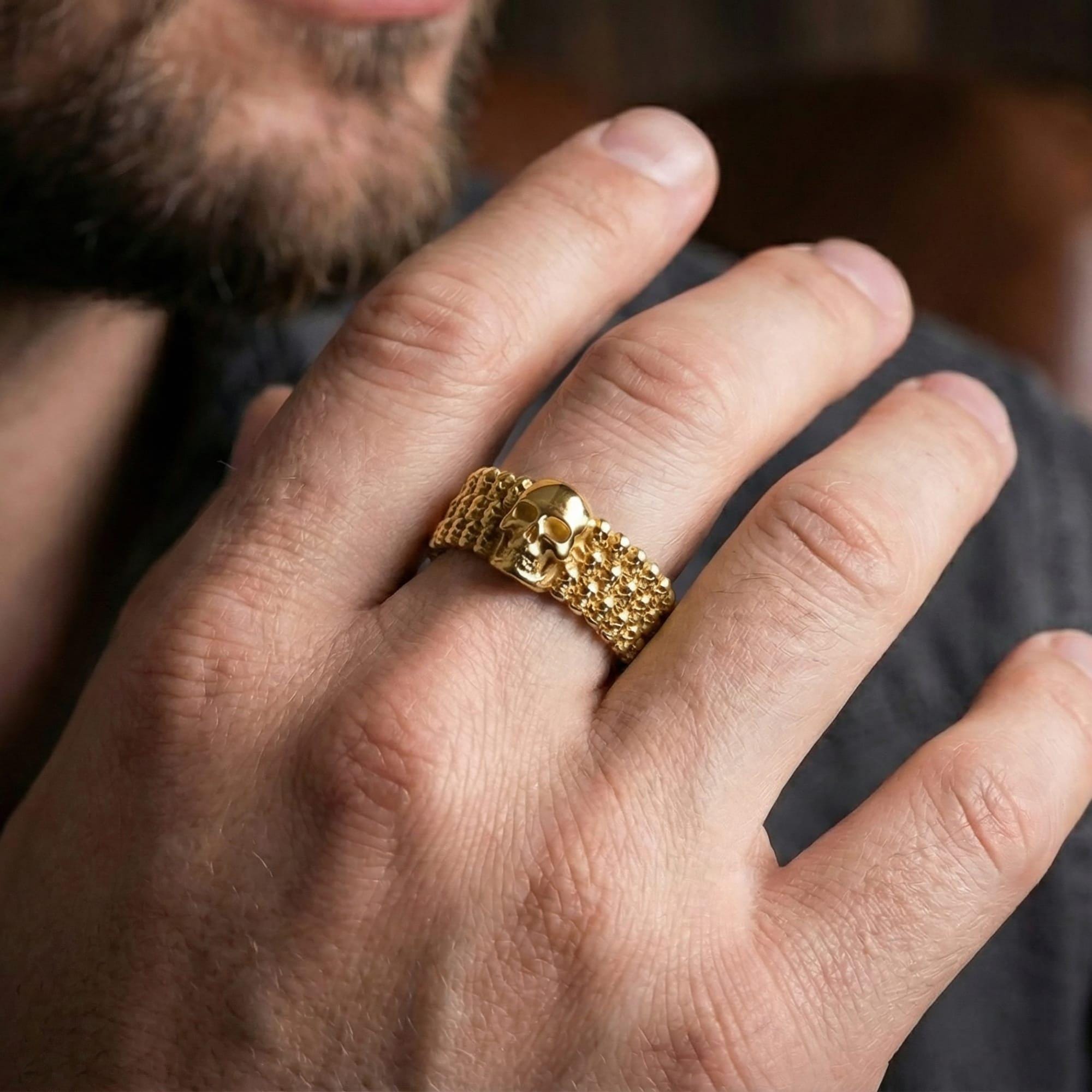 7. Gold plated faceted wedding band worn by man as a contemporary luxury ring with strong architectural presence