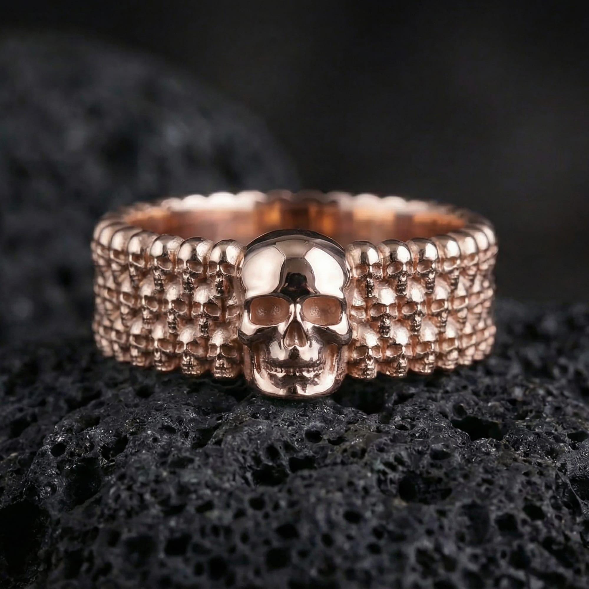 Rose gold plated faceted unisex band ring presented on volcanic rock with warm metallic glow and premium sculpted texture