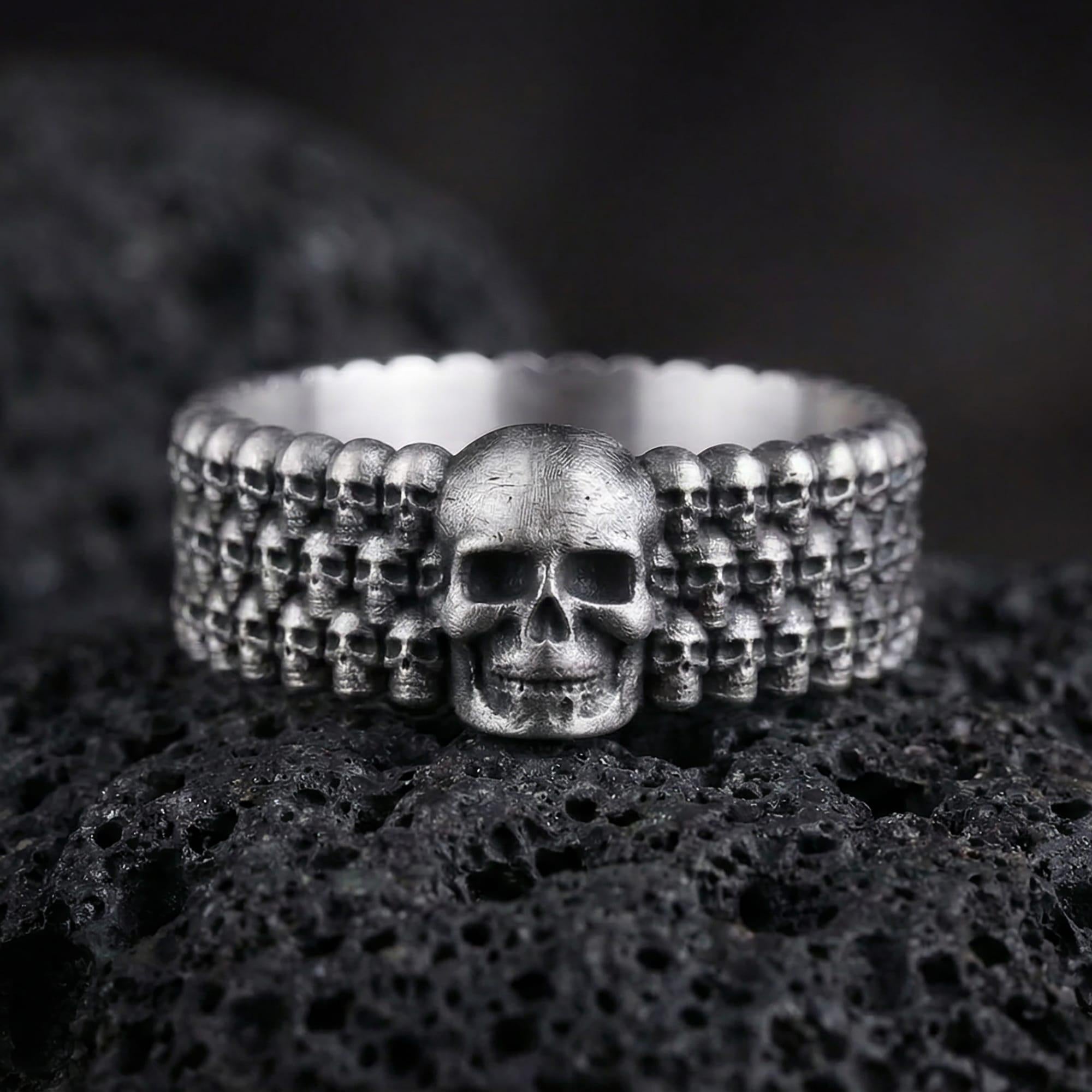 Oxidized faceted geometric band ring photographed on volcanic rock with sharp prism edges and matte industrial finish