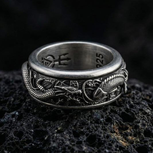 Oxidized spinning dragon and carp fish ring photographed on volcanic rock featuring high-relief oriental myth texture and rotating band design