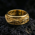 Load image into Gallery viewer, Gold plated dragon and koi inspired spinner ring showcased on volcanic rock symbolizing power prosperity and transformation
