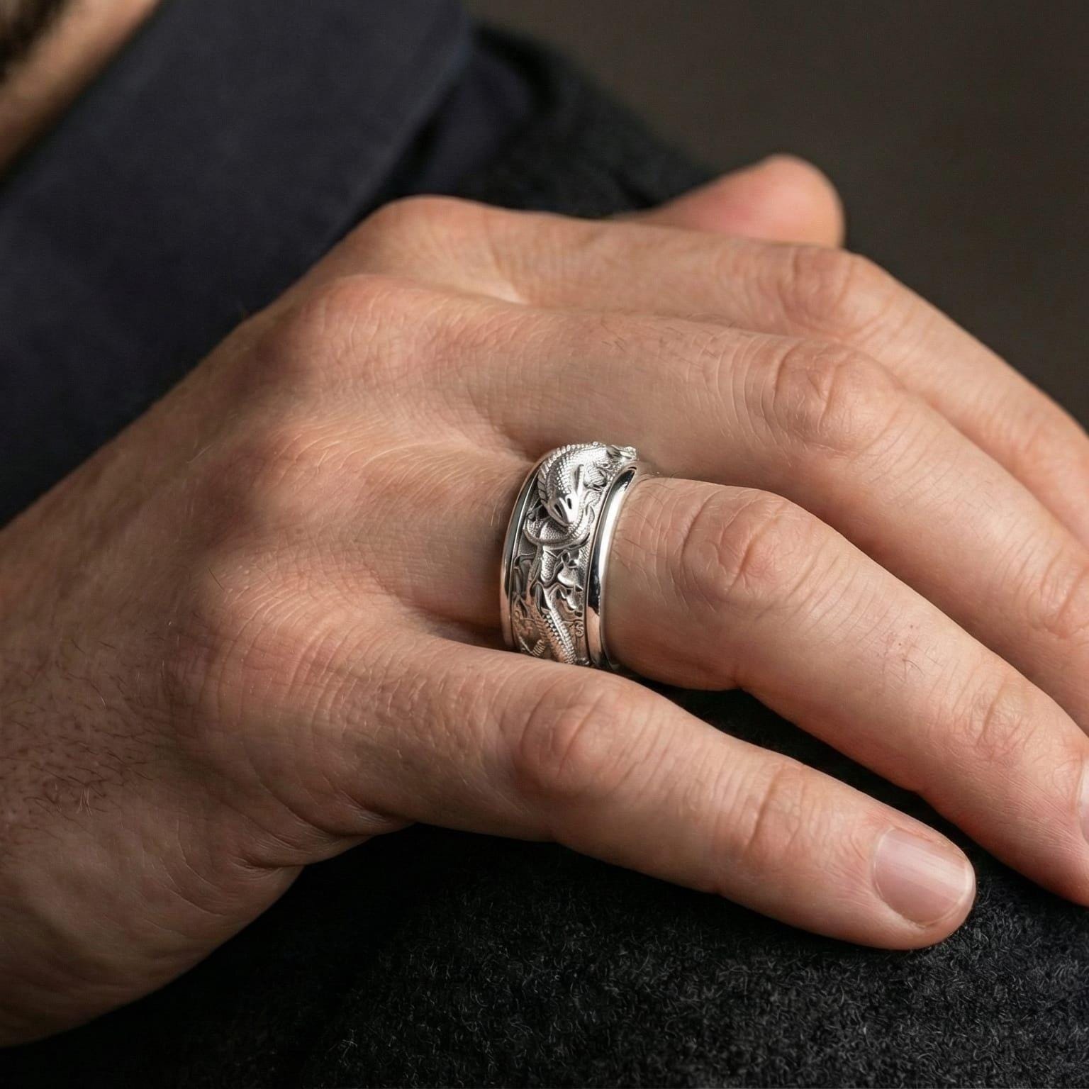 Polished silver dragon and carp fish ring worn on hand emphasizing sculpted relief detail and smooth spinner function