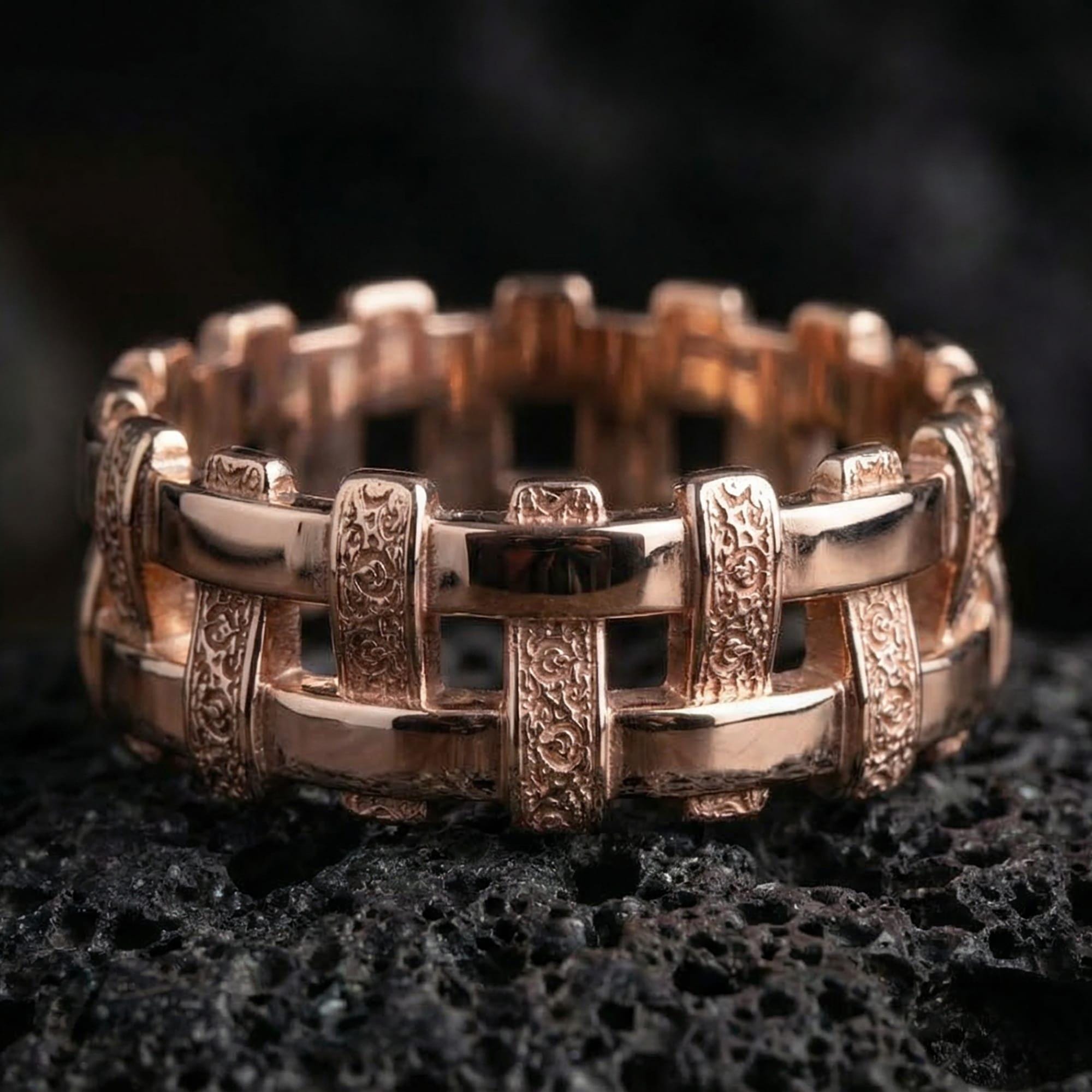 Rose gold plated wicker weave ring presented on volcanic rock surface with warm tone and handcrafted pattern detail