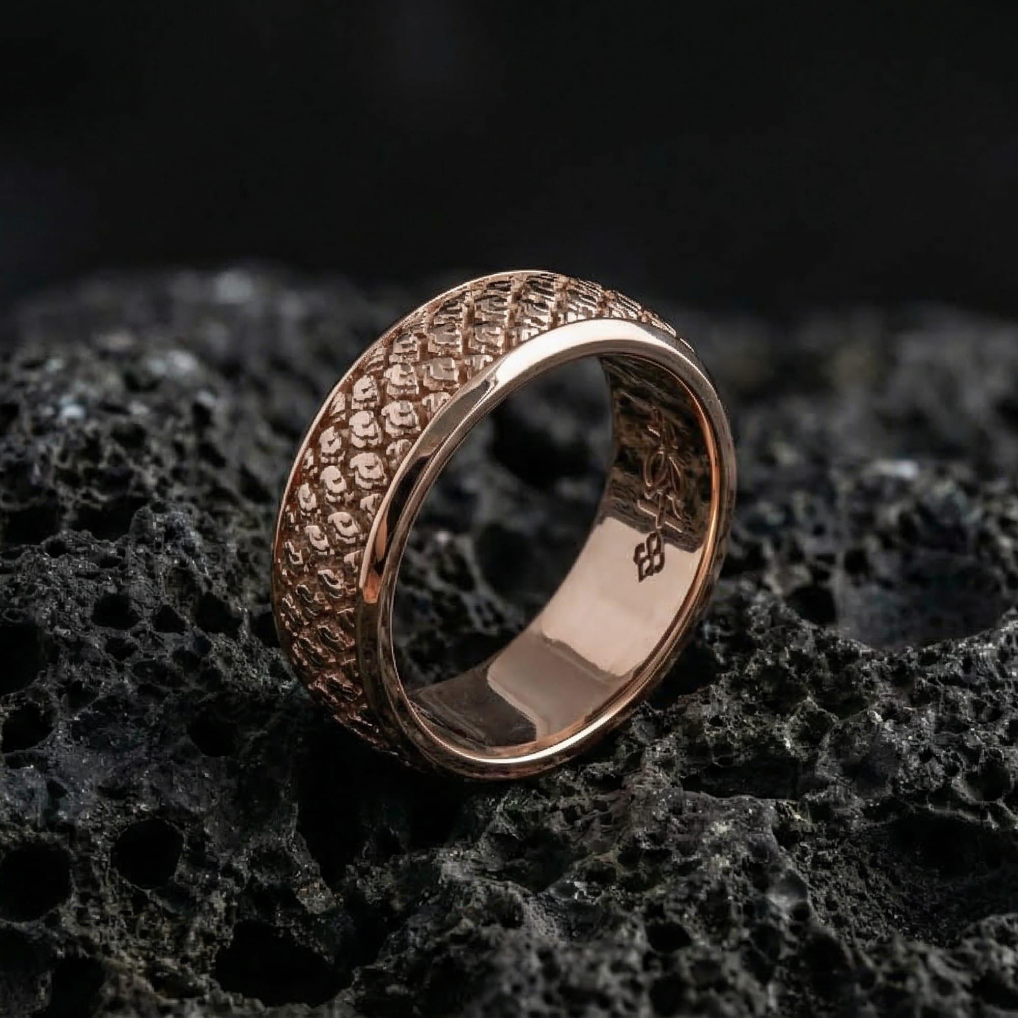 Rose gold plated Japanese kumo cloud band ring presented on volcanic rock surface, emphasizing premium contrast, intricate swirl detailing, and elegant silhouette