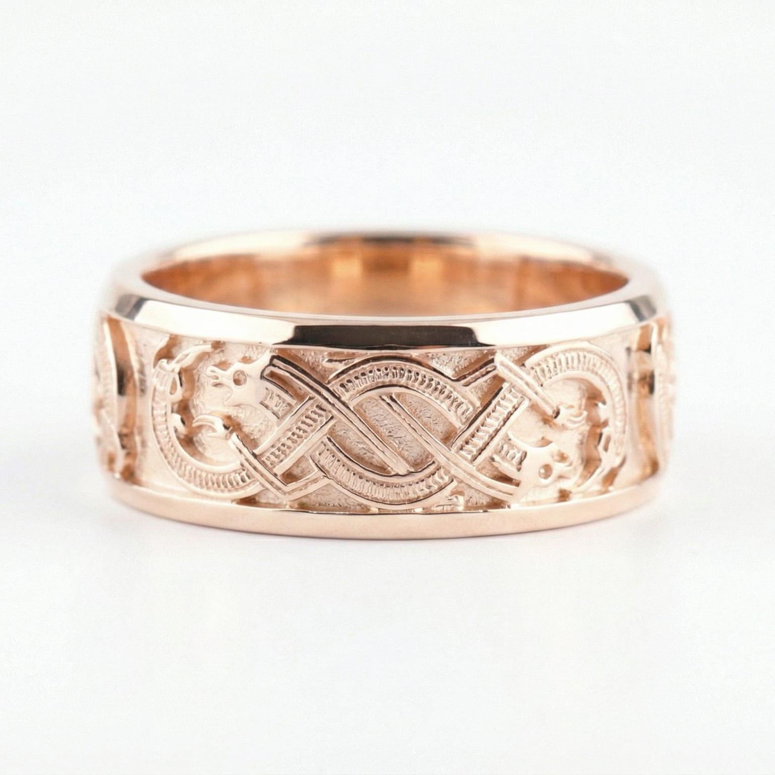 Rose Gold Slavic dragon motif ring displayed on a white surface highlighting Celtic-style knot details and bold mythology aesthetic