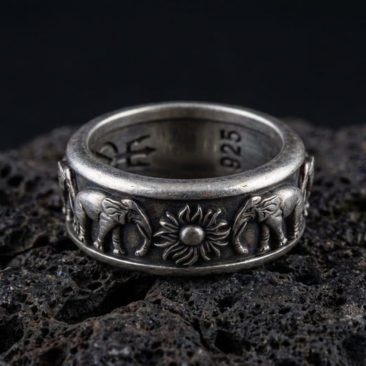 Oxidized spinner fidget elephant ring photographed on volcanic rock, 925 sterling silver band with raised elephant and sun motif, engravable inside