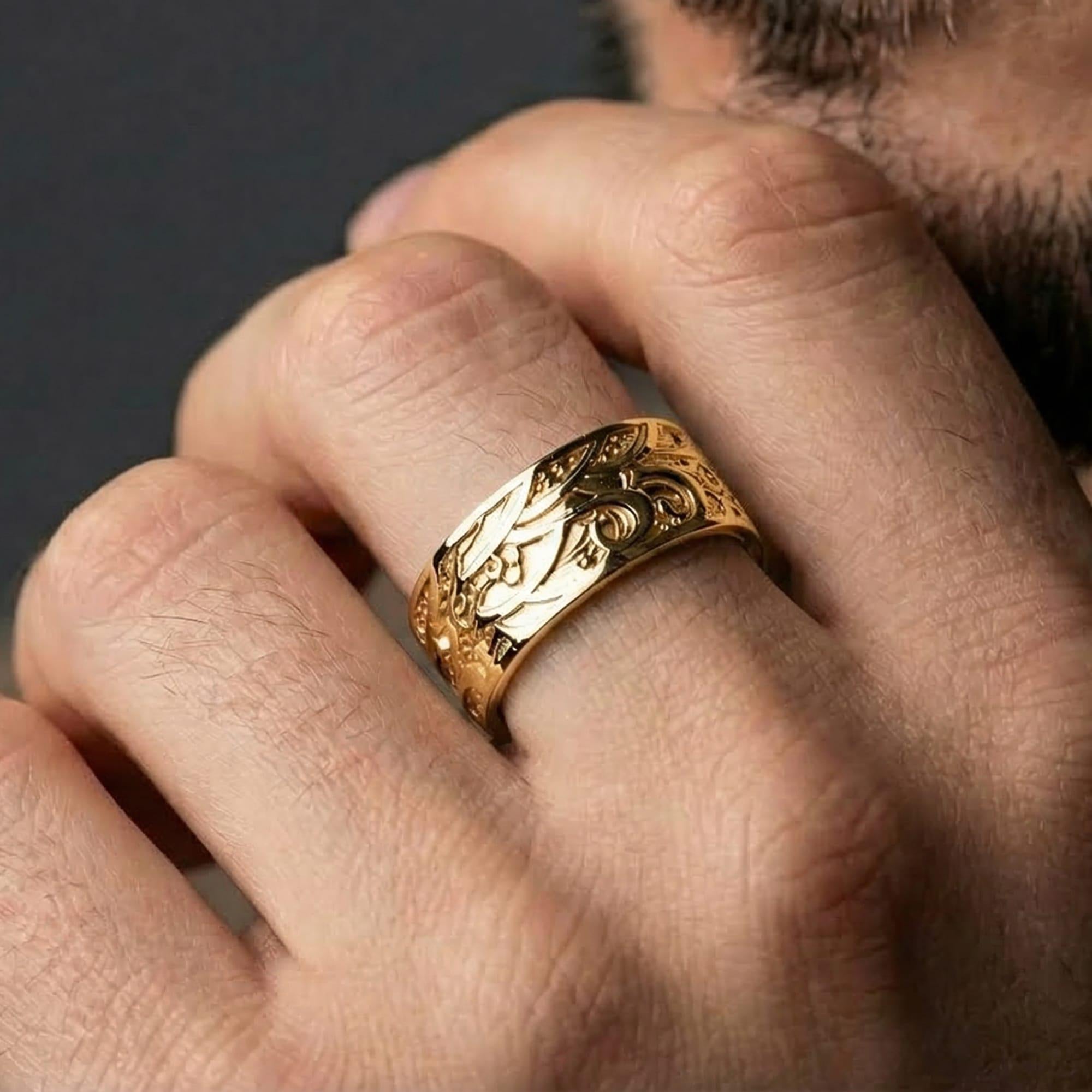 Gold plated wave motif band ring worn by man as a bold anniversary statement ring with ocean-current inspired engraving