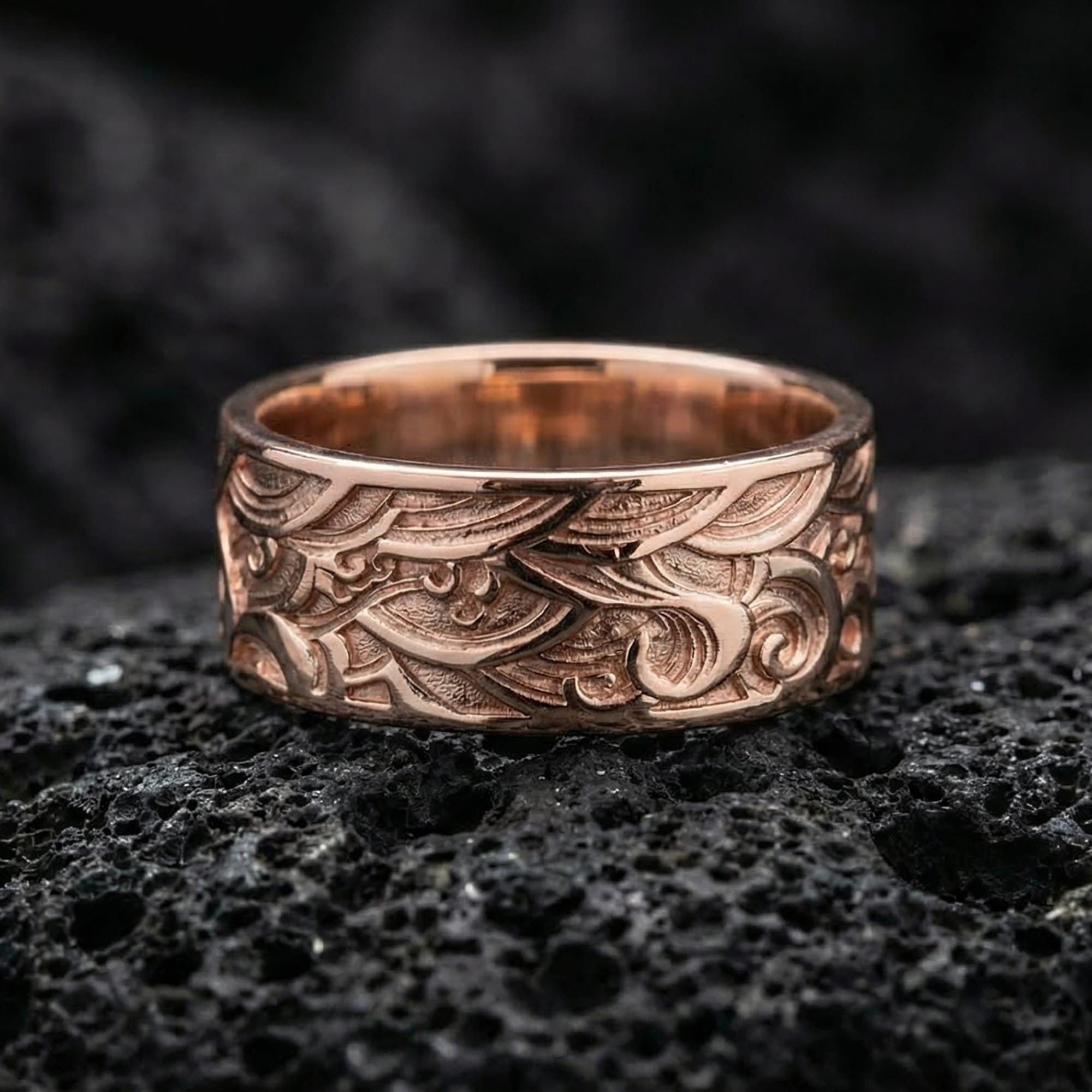 Rose gold plated vintage wave pattern band ring presented on volcanic rock, emphasizing sculpted flowing curves and modern-unisex style appeal