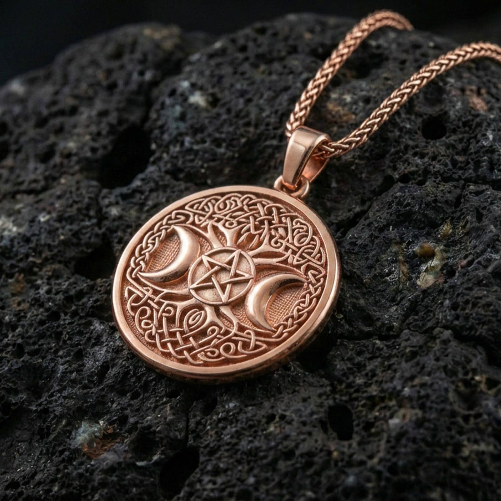 Rose gold plated triple moon pentagram medallion on dark volcanic stone, Celtic knot border and pentacle center