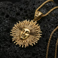 Load image into Gallery viewer, Gold plated Helios sun pendant on volcanic rock, radiant sunburst medallion with face relief and braided chain
