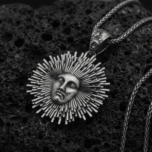 Oxidized 925 sterling silver Helios sun pendant on volcanic rock, radiant sunburst rays with face relief and braided chain