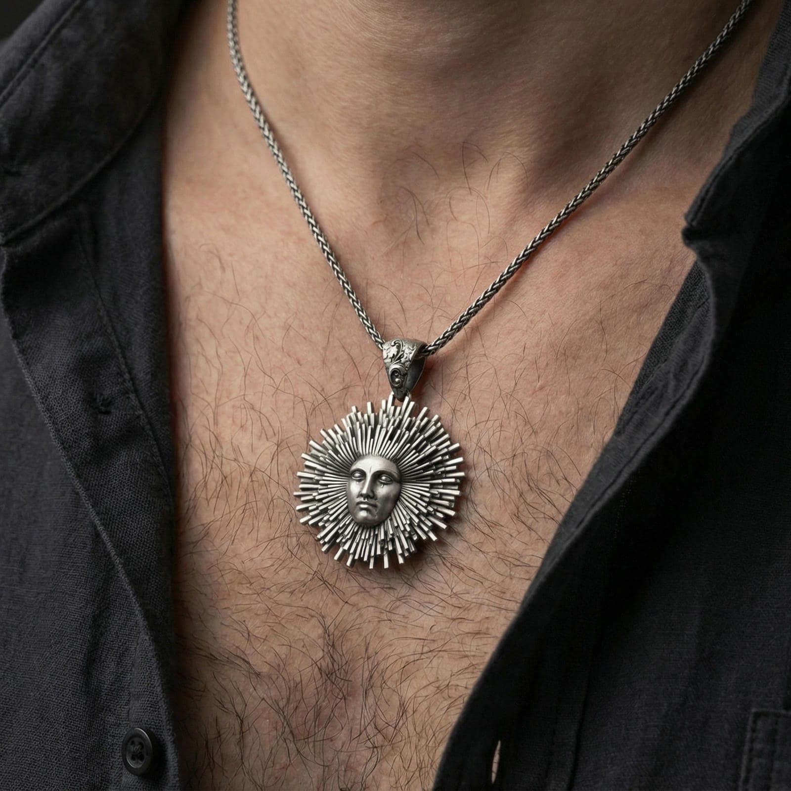 Oxidized 925 sterling silver Helios sun pendant worn on neck, sunburst rays and face relief on braided chain