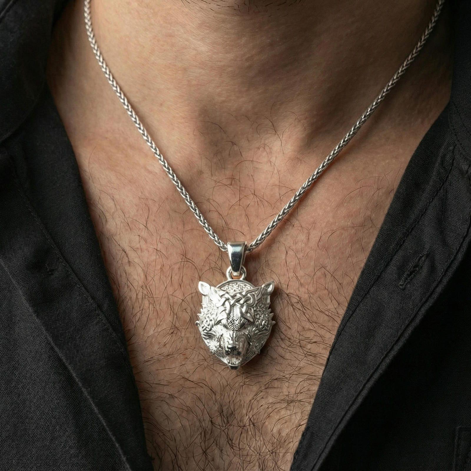 Polished silver Fenrir wolf head necklace worn on neck, Viking Nordic wolf pendant with intricate knot patterns