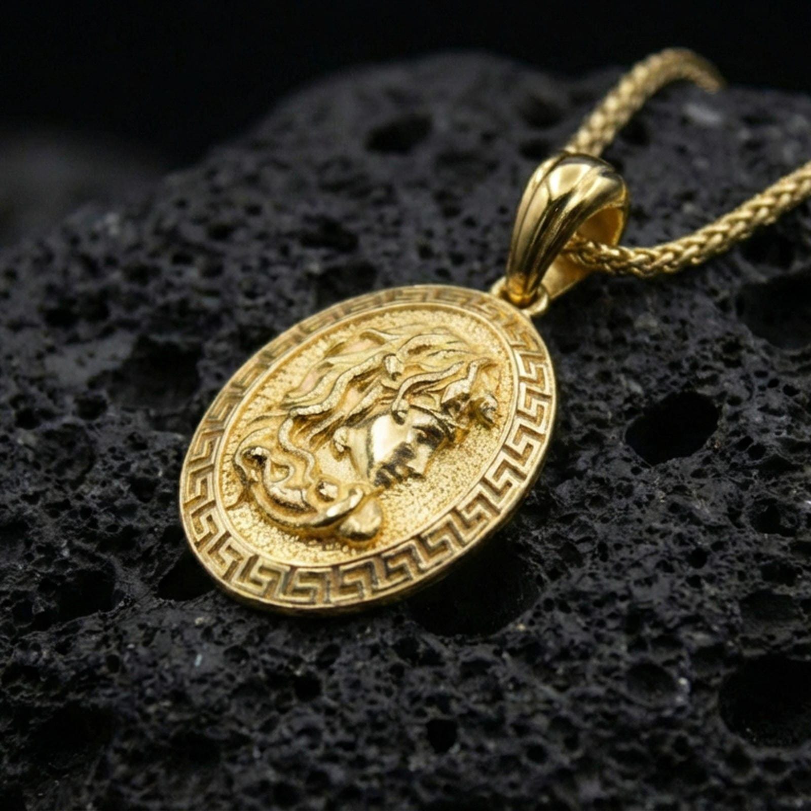 Gold plated Medusa coin pendant on volcanic rock, Greek key border medallion with classical Greek mythology face relief