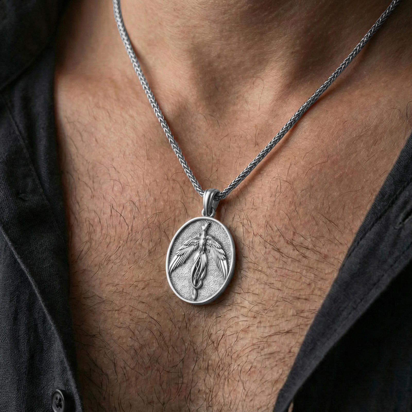 Polished silver phoenix medallion necklace worn on neck, flying bird pendant with clean sculpted feather lines