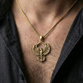 Load image into Gallery viewer, Gold plated phoenix pendant worn on neck, firebird necklace with luxury glow and sculpted wing contours
