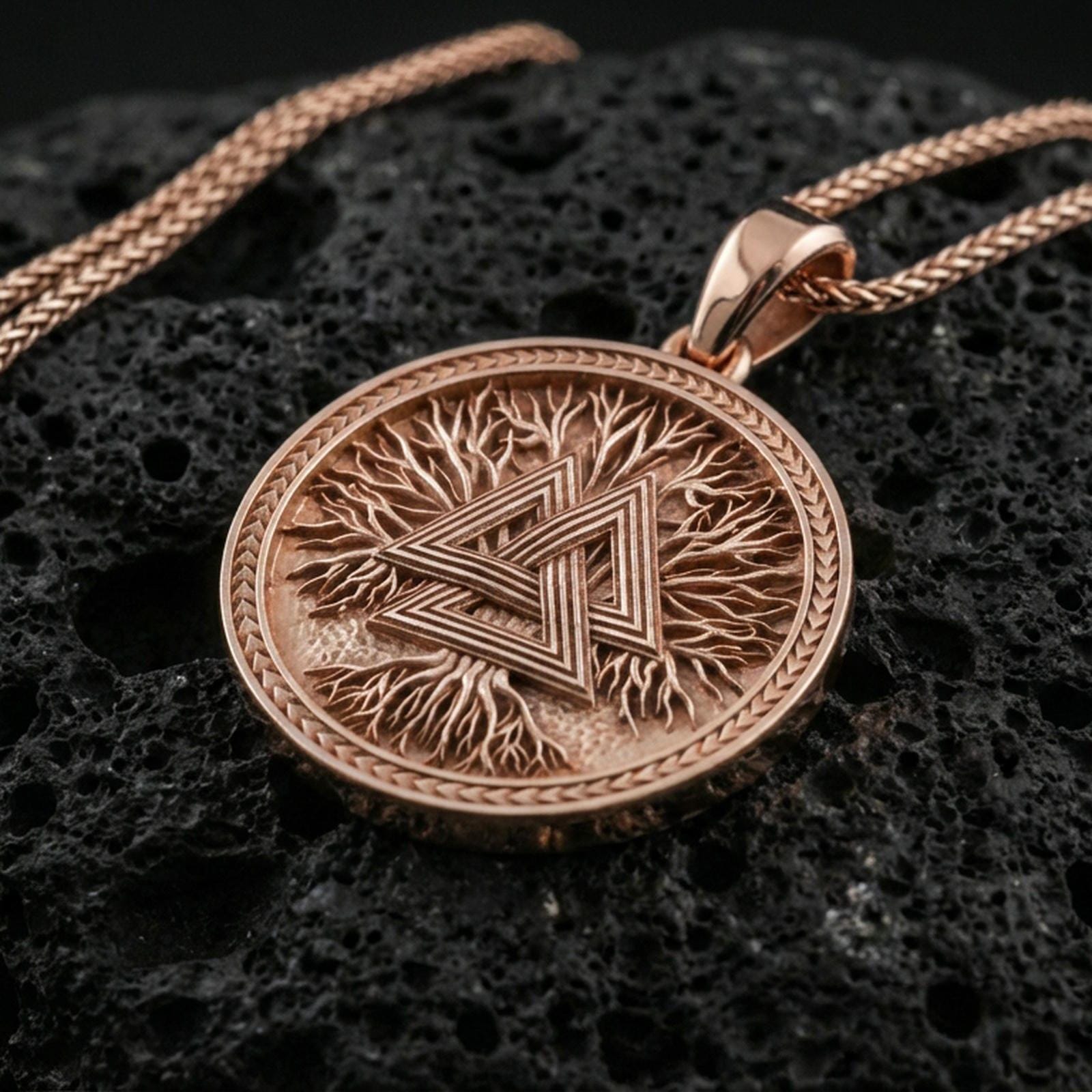 Rose gold plated valknut necklace on dark volcanic stone, Norse valknut medallion pendant with bold geometric lines