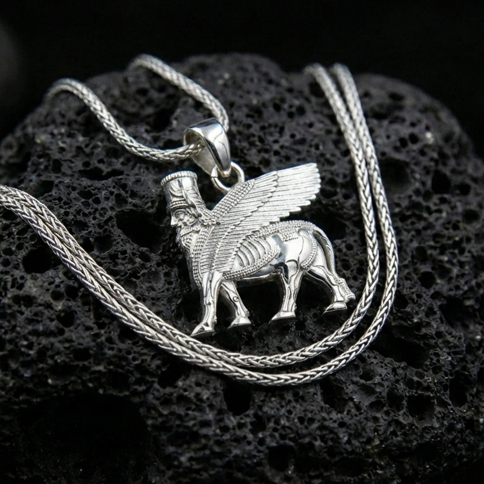 Polished silver lamassu necklace on porous volcanic stone, Mesopotamian protective talisman pendant with fine relief detail