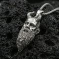 Load image into Gallery viewer, Polished silver Mimir head necklace on porous volcanic stone, detailed Viking face pendant with carved horn accents

