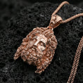 Load image into Gallery viewer, Rose gold plated deity head pendant on volcanic rock, dramatic shadows, ultra-detailed relief texture, macro focus
