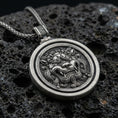 Load image into Gallery viewer, Oxidized sterling silver guardian lion medallion pendant on volcanic rock, rotating disk design, macro product shot
