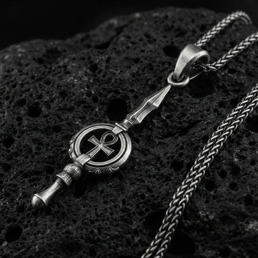 Oxidized sterling silver ankh spear pendant on volcanic rock, ancient Egyptian symbol detail, macro studio shot