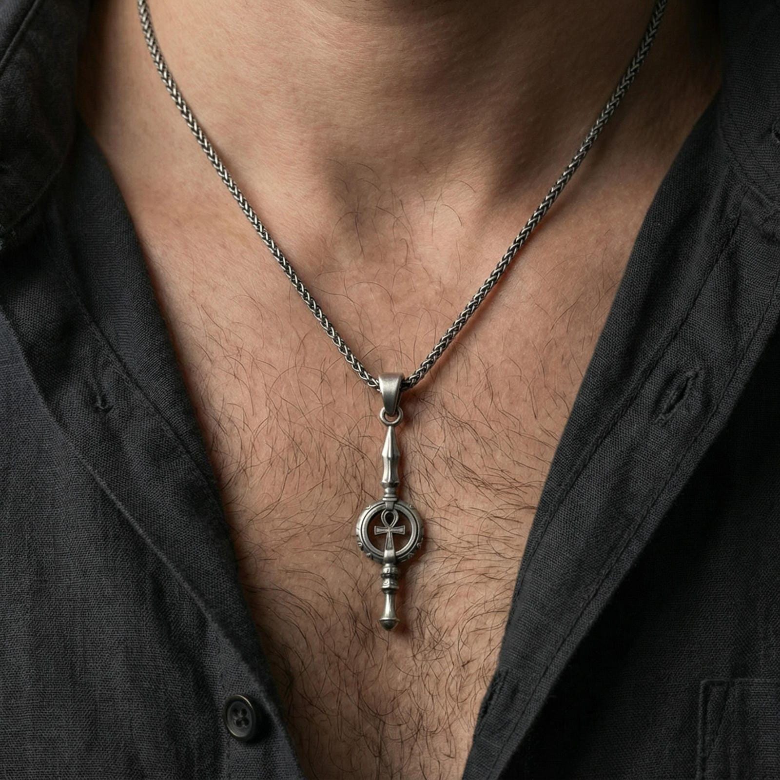 Oxidized ankh spear pendant necklace worn on neck, lifestyle close-up, pendant centered with braided chain
