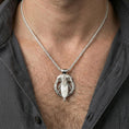 Load image into Gallery viewer, Polished silver raven and spear pendant necklace worn on neck, clean lifestyle framing, reflective finish and crisp edges

