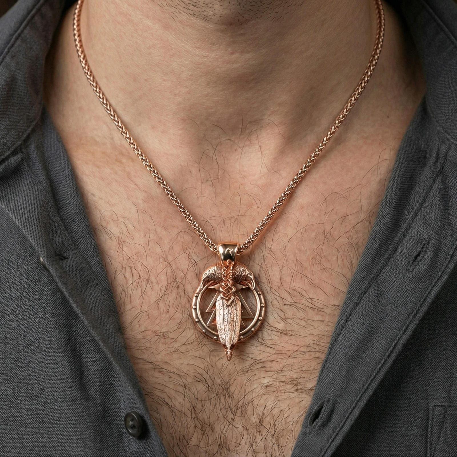 Rose gold plated raven and spear pendant necklace worn on neck, lifestyle wear shot, warm plating tone and sculpted depth