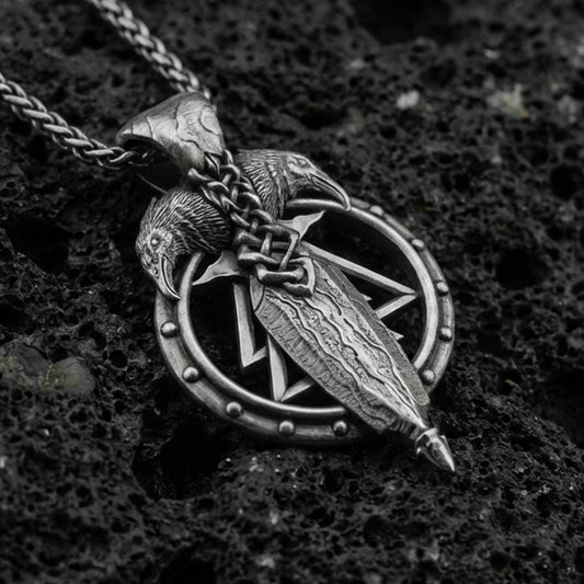Oxidized sterling silver Odin’s spear and raven pendant on volcanic rock, Norse Viking talisman design, macro shot
