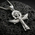 Load image into Gallery viewer, Polished silver winged ankh cross necklace on volcanic rock, crisp etching and raised relief wings, close-up lighting
