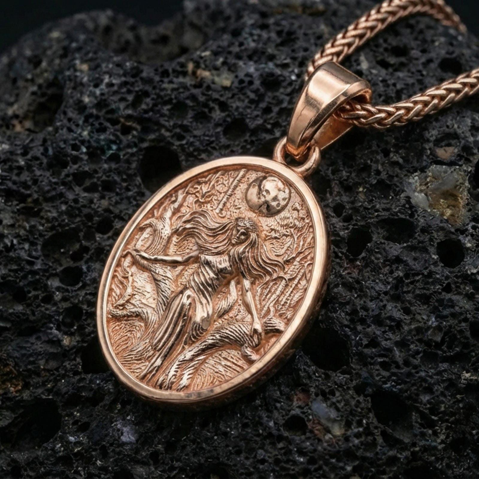 Rose gold plated Hela pendant on volcanic rock, textured lava stone background, detailed figure relief and night-sky motif