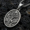 Load image into Gallery viewer, Oxidized sterling silver Hela pendant on volcanic rock, Norse mythology goddess relief with moon detail, macro studio shot
