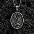 Load image into Gallery viewer, Oxidized sterling silver phoenix bird pendant on volcanic rock, rebirth symbol medallion with detailed feathers, macro shot
