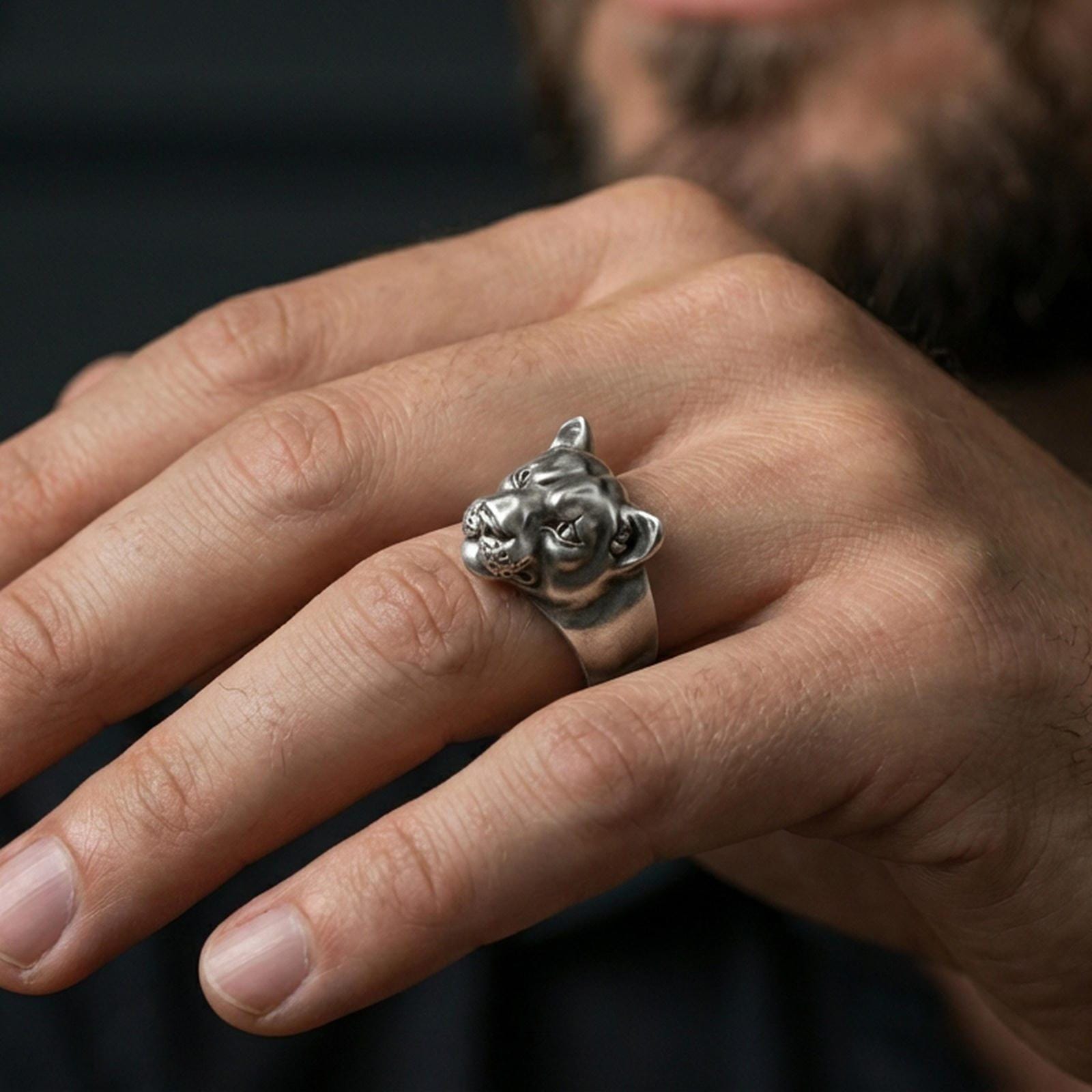 Oxidized puma head ring worn on finger, lifestyle close-up, bold wild cat statement ring profile view
