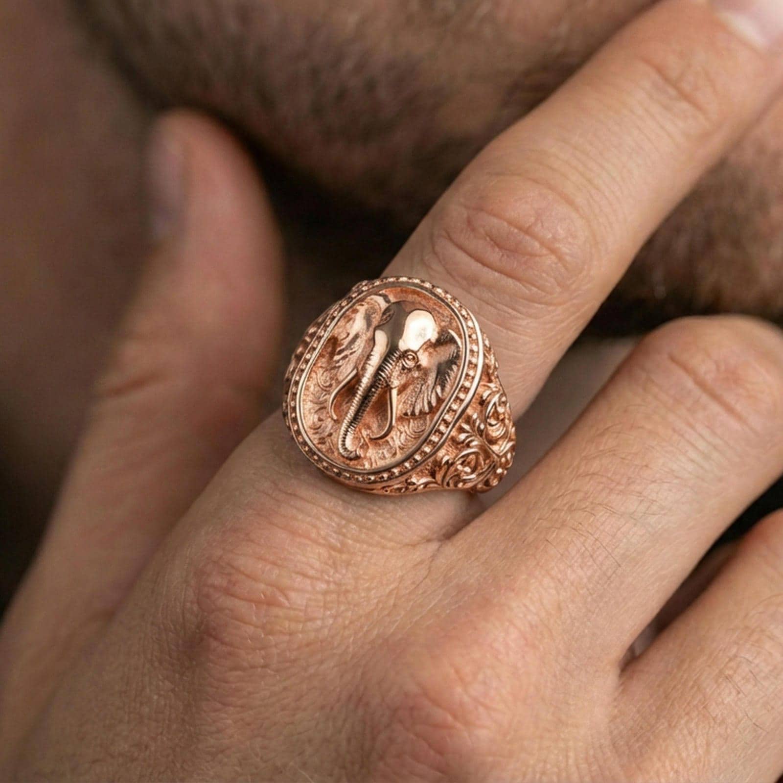 Rose gold plated elephant signet ring worn on finger, lifestyle wear photo, elephant totem ring highlighting tusk and trunk details