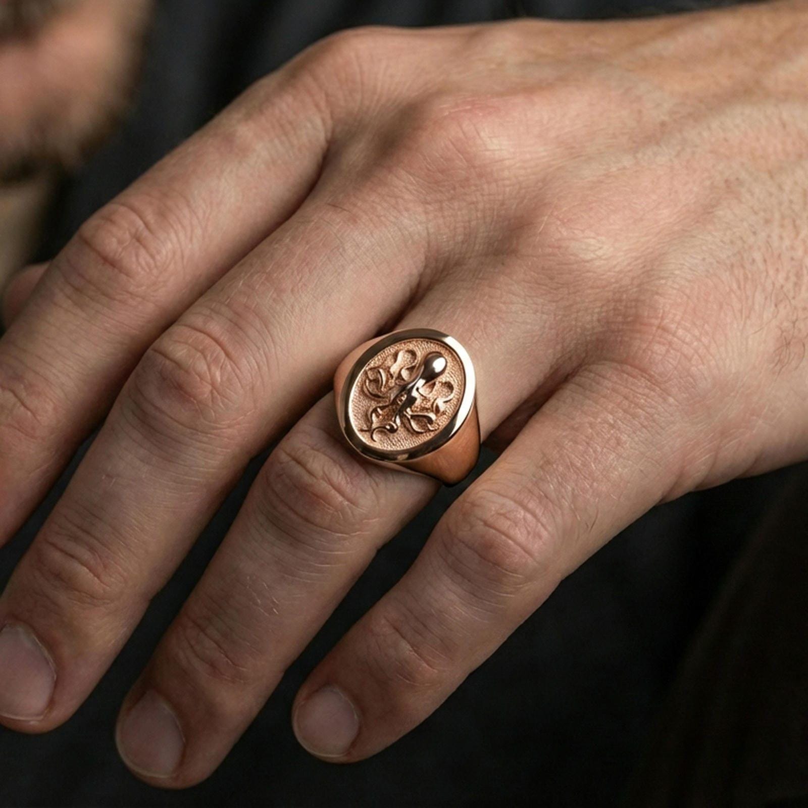 Rose gold plated octopus signet ring worn on finger, lifestyle wear shot, octopus symbol ring emphasizing tentacle relief and round face