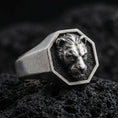Load image into Gallery viewer, Oxidized sterling silver lioness signet ring on volcanic rock, octagon face with raised lioness head relief and dark textured background, macro product photo
