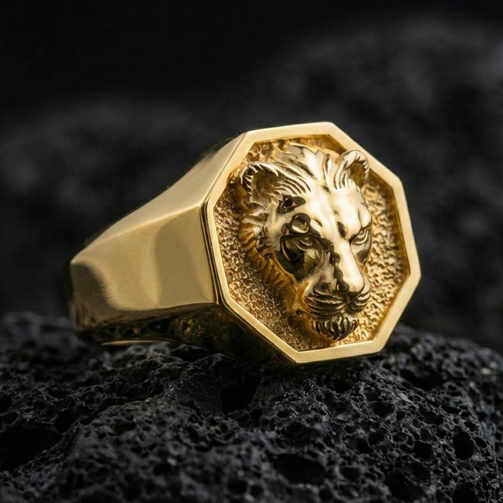 Gold plated lioness signet ring on volcanic rock, bold octagon signet with lioness head emblem and textured recessed field, premium studio lighting