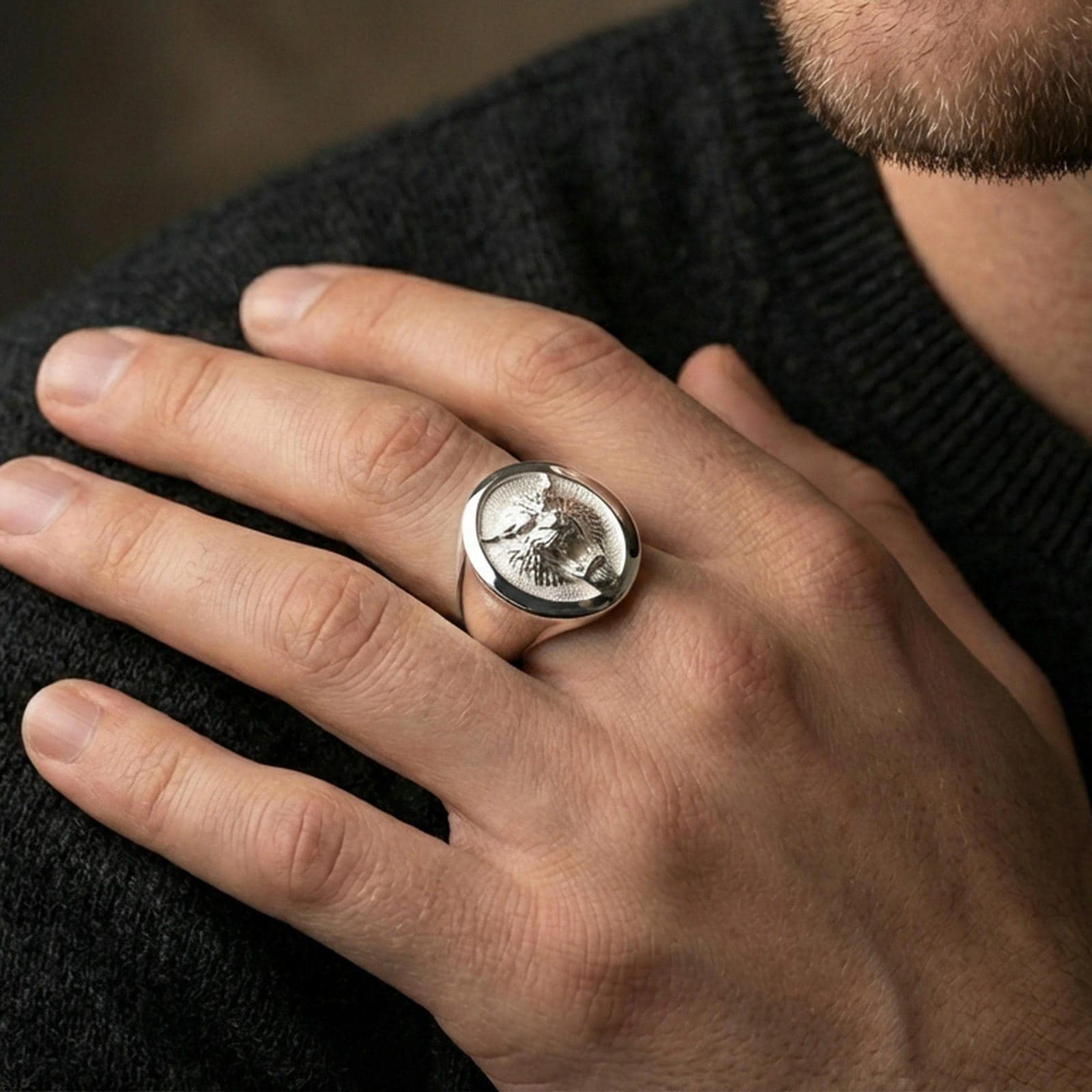 Polished silver tiger signet ring worn on finger, lifestyle hand shot, oval tiger emblem signet with crisp rim detail