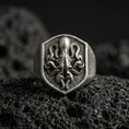 Load image into Gallery viewer, Oxidized sterling silver octopus signet ring on volcanic rock, shield-shaped face with raised octopus emblem and dark textured background, macro jewelry photo
