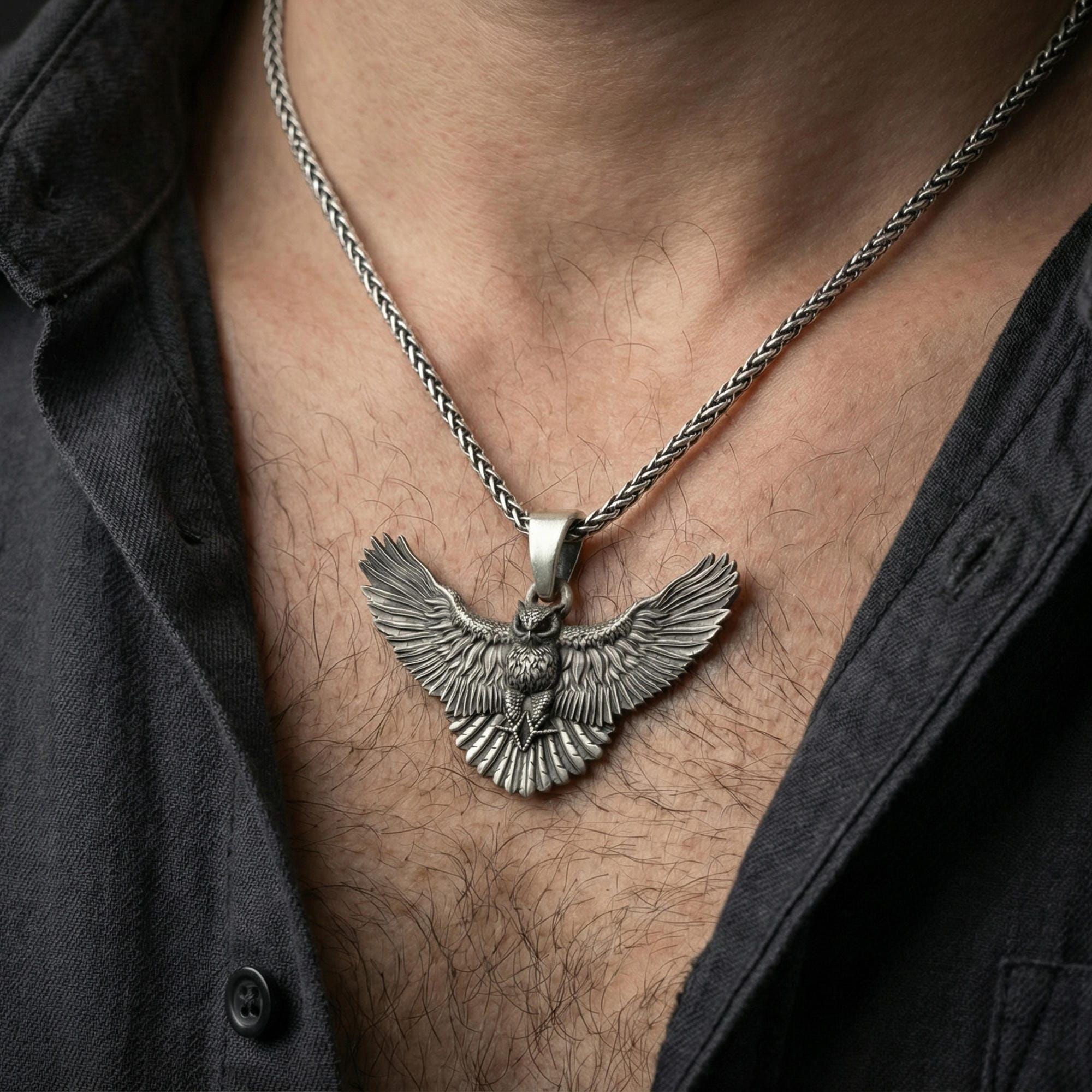 Oxidized owl pendant necklace worn on neck, lifestyle close-up on dark shirt, clean premium studio look