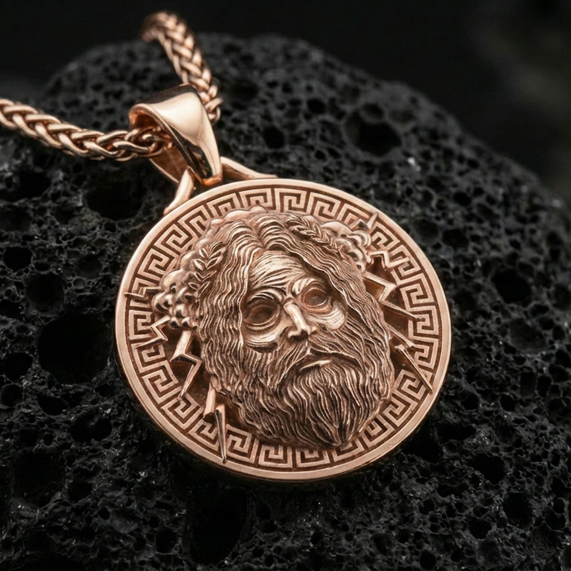 Rose gold plated Zeus jewelry pendant on volcanic rock, premium macro product photo, sharp mythology coin relief and bail
