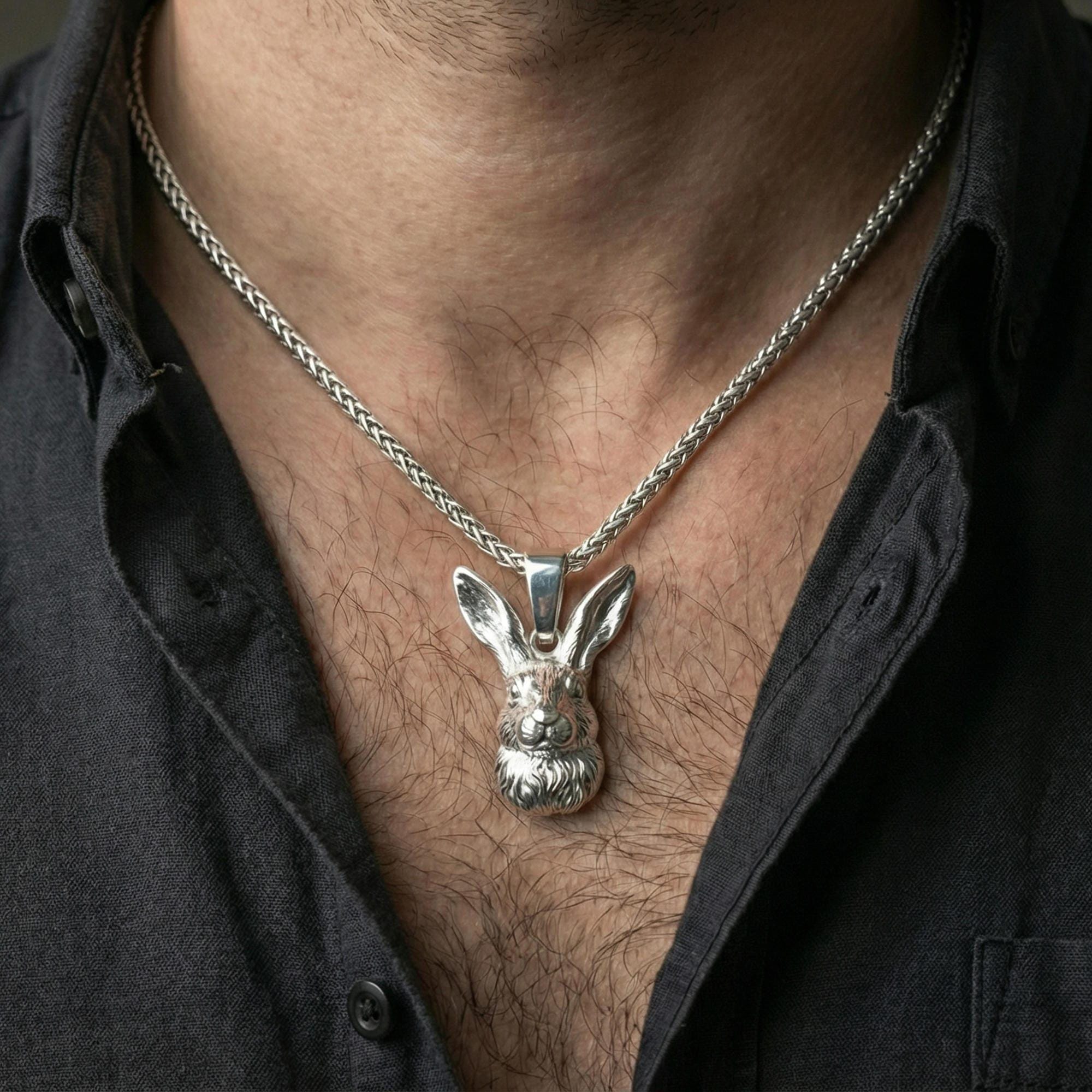 Polished silver rabbit pendant on chain worn on neck, natural lifestyle framing, rabbit face and ears clearly visible