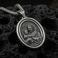 Load image into Gallery viewer, Oxidized Saint Joseph rotating pendant on textured volcanic rock, macro close-up, Catholic medallion with halo detail, premium studio lighting
