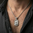 Load image into Gallery viewer, Polished silver Mary and Child pendant on chain worn on neck, natural lifestyle framing, religious relief clearly visible
