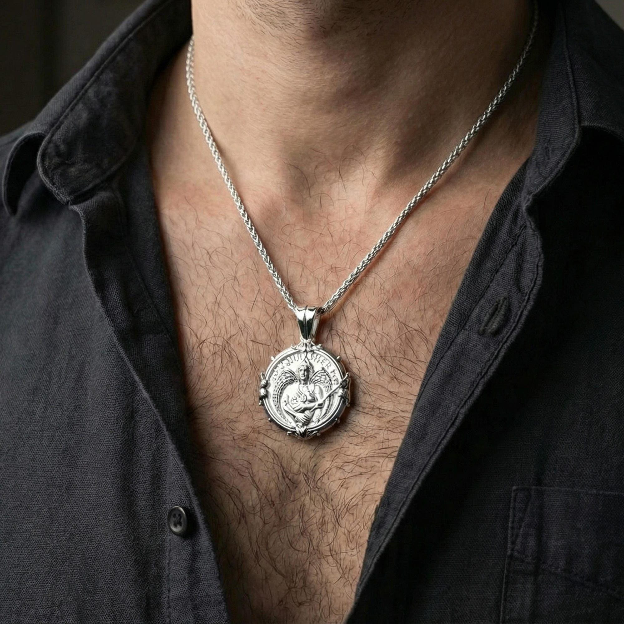 Polished silver Saint Uriel pendant on chain worn on neck, natural lifestyle framing, wings and sword clearly visible
